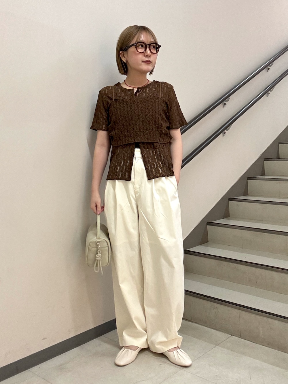 ブラウン系のTシャツ/カットソー、ホワイト系のその他パンツ、ベージュ系のハンドバッグを着用したレディースの春コーディネートの2枚目の写真