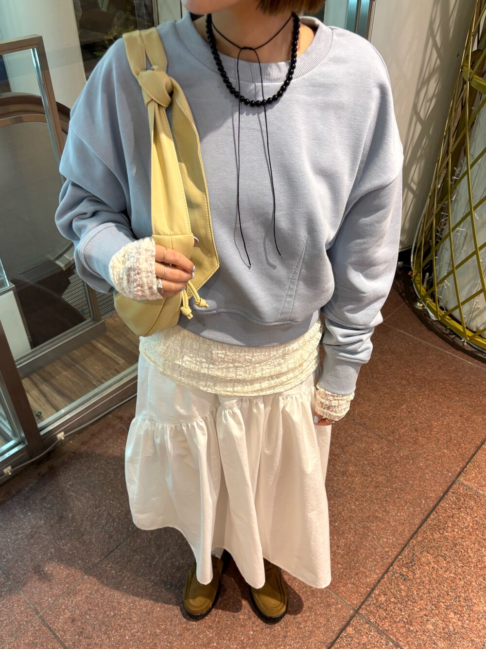 ブルー系のスウェット、ホワイト系のTシャツ/カットソー、ホワイト系のスカートを着用したレディースの冬コーディネートの4枚目の写真