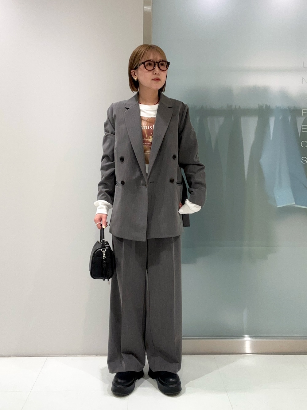 グレー系のスラックス、ブラック系のハンドバッグ、ブラック系のその他シューズを着用したレディースの春コーディネートの3枚目の写真