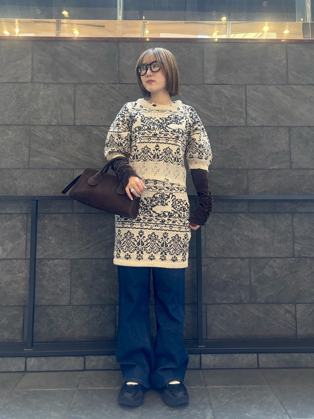 ベージュ系のニット/セーター、ベージュ系のスカート、ブルー系のデニムパンツを着用したレディースの冬コーディネートの5枚目の写真