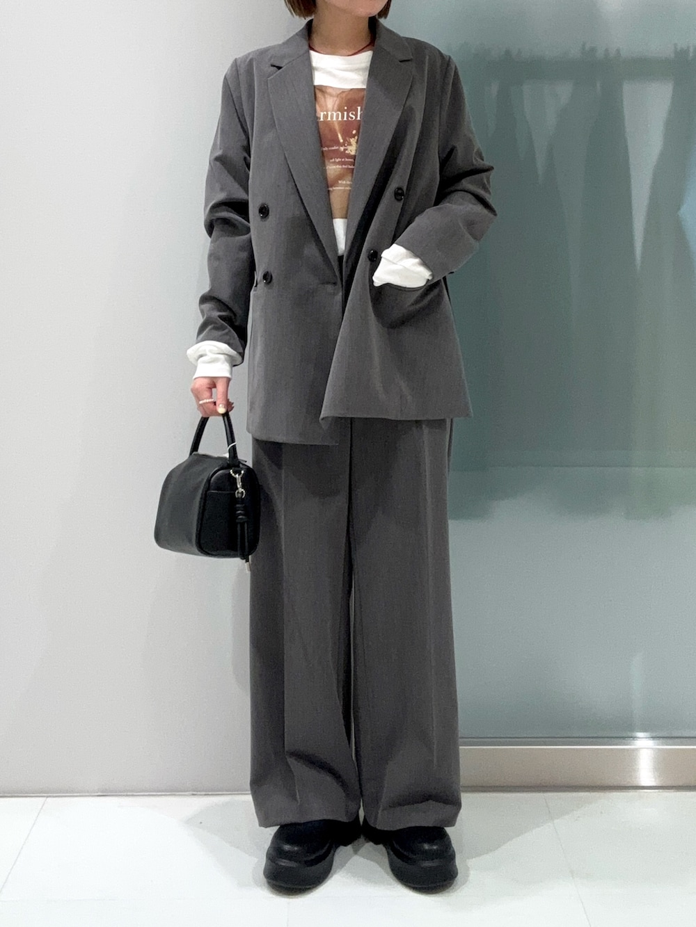 グレー系のスラックス、ブラック系のハンドバッグ、ブラック系のその他シューズを着用したレディースの春コーディネートの5枚目の写真