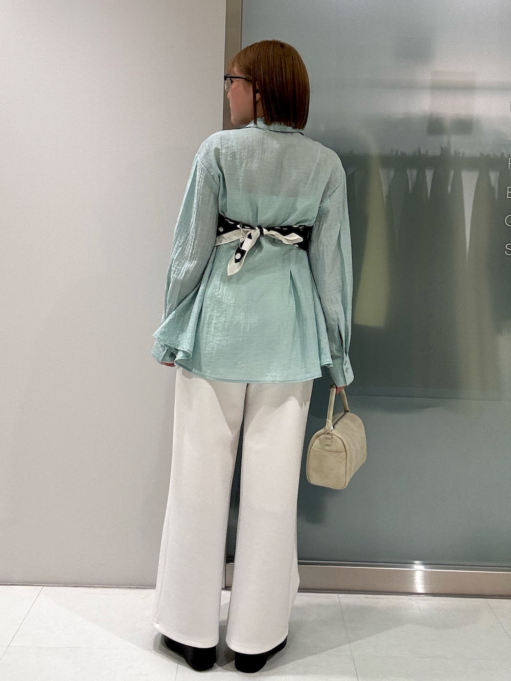 ベージュ系のハンドバッグ、ホワイト系のその他パンツ、グリーン系のシャツ/ブラウスを着用したレディースの春コーディネートの5枚目の写真