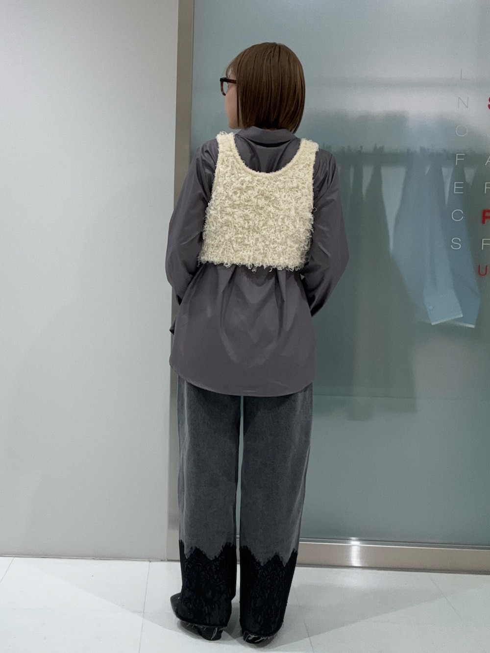 ホワイト系のシャツ/ブラウス、ホワイト系のベスト、グレー系のデニムパンツを着用したレディースの春コーディネートの4枚目の写真