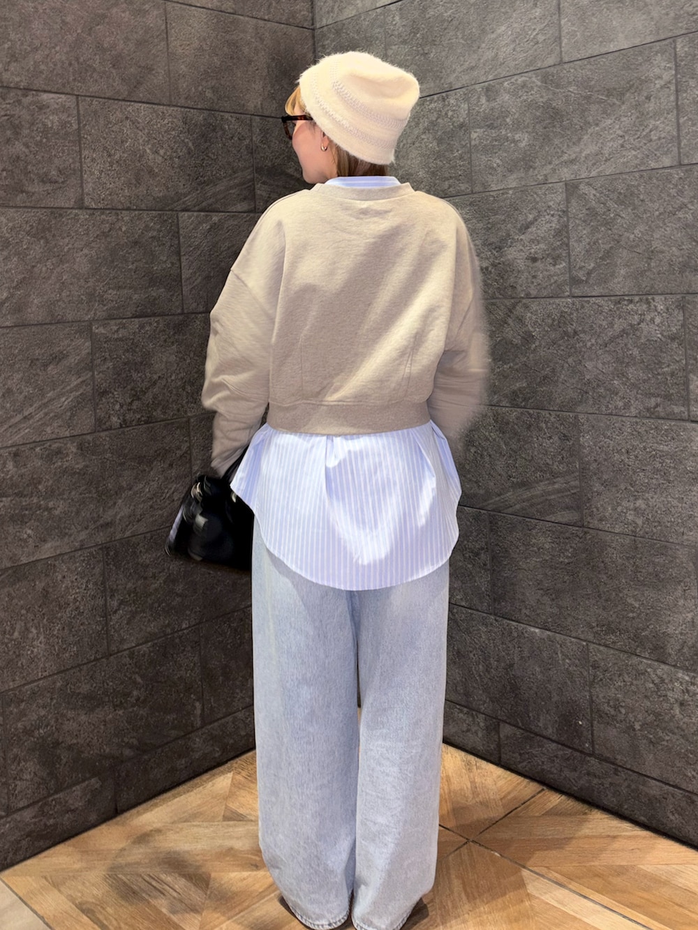 ブラック系のボストンバッグ、ブルー系のデニムパンツ、ベージュ系のスウェットを着用したレディースの冬コーディネートの5枚目の写真