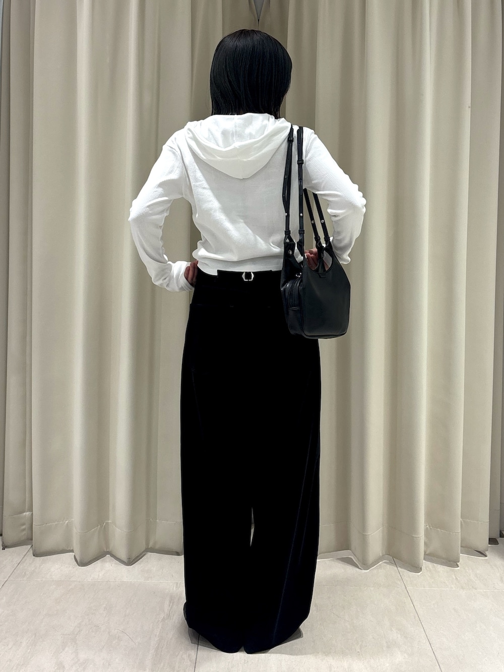 ホワイト系のパーカー、ブラック系のその他パンツ、ブラック系のショルダーバッグを着用したレディースの秋コーディネートの3枚目の写真