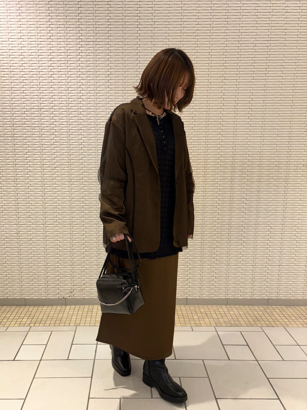 ブラウン系のその他アウター、ブラウン系のワンピース、ブラック系のTシャツ/カットソーを着用したレディースの冬コーディネートの3枚目の写真