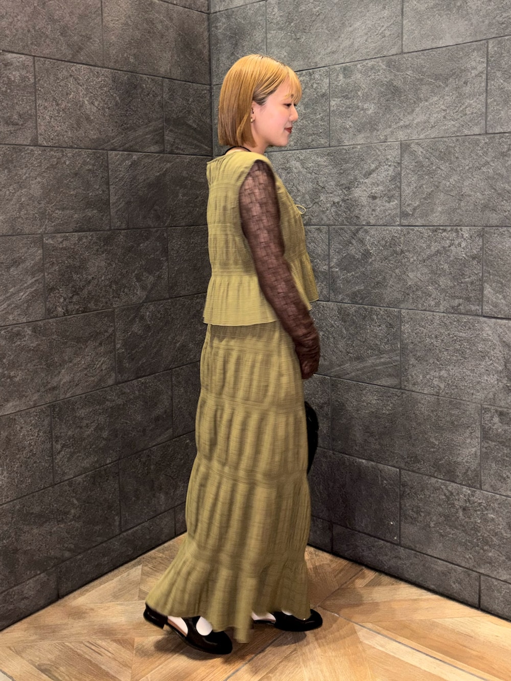 ブラウン系のTシャツ/カットソー、ブラック系のローファー、ブラック系のショルダーバッグを着用したレディースの冬コーディネートの2枚目の写真