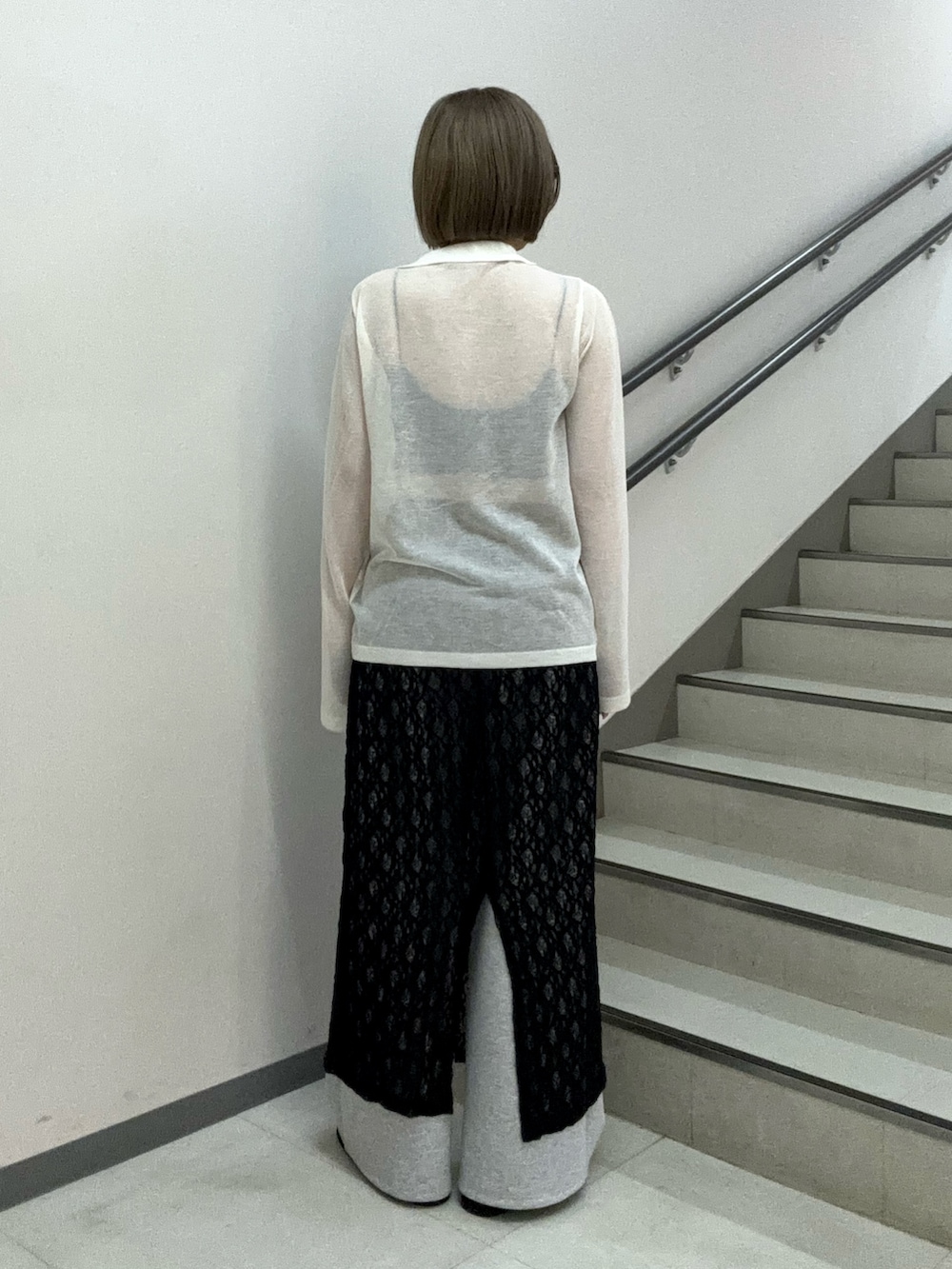 ホワイト系のニット/セーター、ブラック系のキャミソール、ブラック系のスカートを着用したレディースの春コーディネートの3枚目の写真