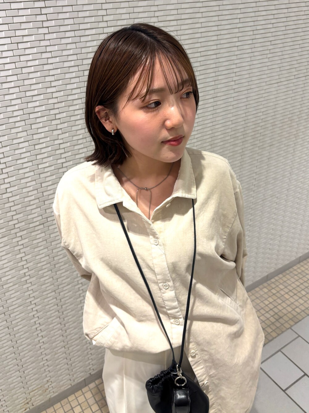 ホワイト系のシャツ/ブラウス、ホワイト系のその他パンツ、ブラック系のショルダーバッグを着用したレディースの秋コーディネートの4枚目の写真