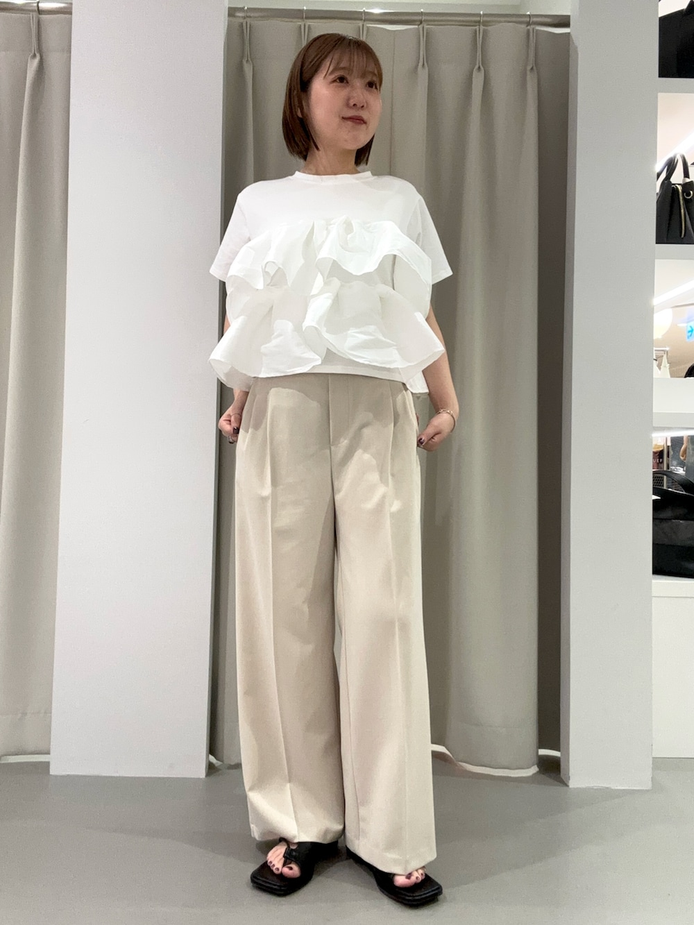 ホワイト系のTシャツ/カットソー、ベージュ系のその他パンツ、ブラック系のサンダルを着用したレディースの夏コーディネートの2枚目の写真