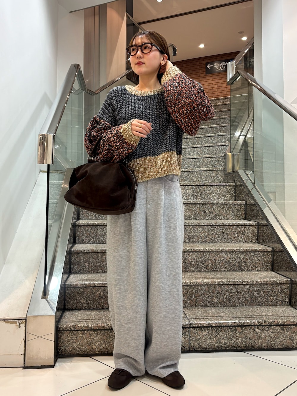 グレー系のニット/セーター、グレー系のその他パンツ、ブラウン系のスニーカーを着用したレディースの冬コーディネートの2枚目の写真