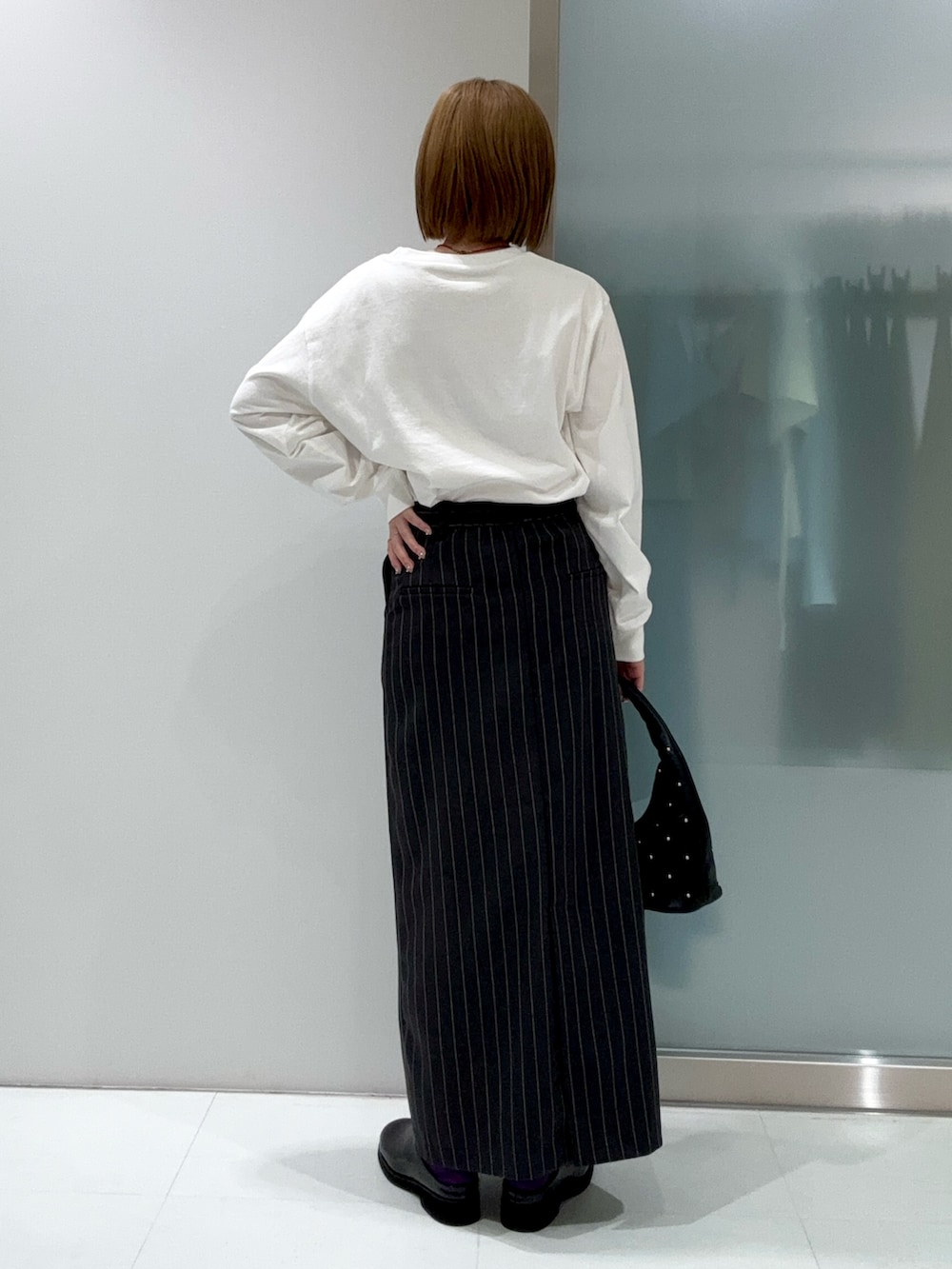 グレー系のスカート、その他のTシャツ/カットソー、ブラック系のハンドバッグを着用したレディースの春コーディネートの5枚目の写真