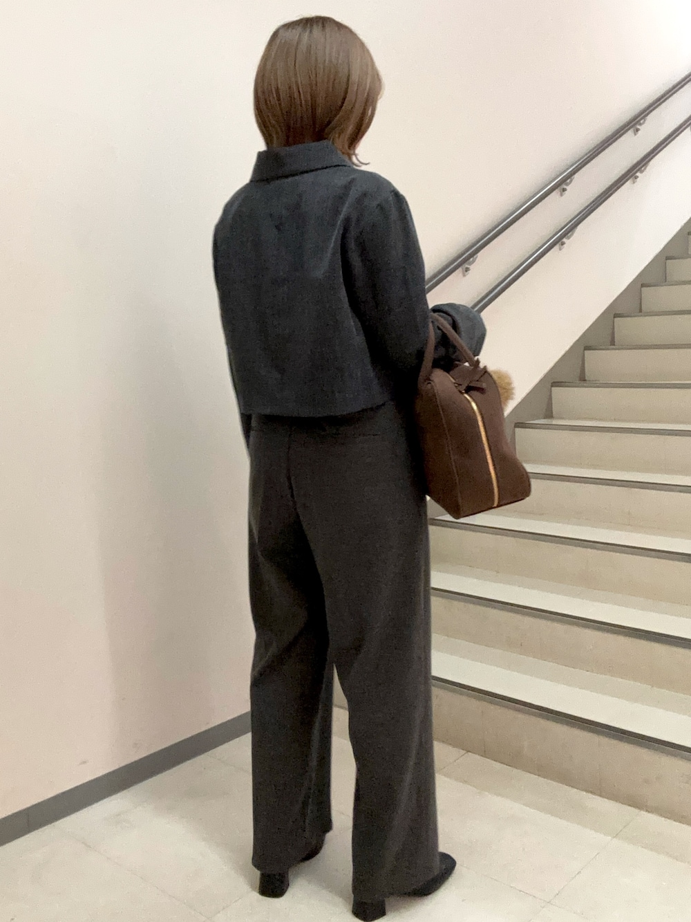 グレー系のその他パンツ、ブラウン系のボストンバッグ、ブラック系のブーツを着用したレディースの秋コーディネートの4枚目の写真