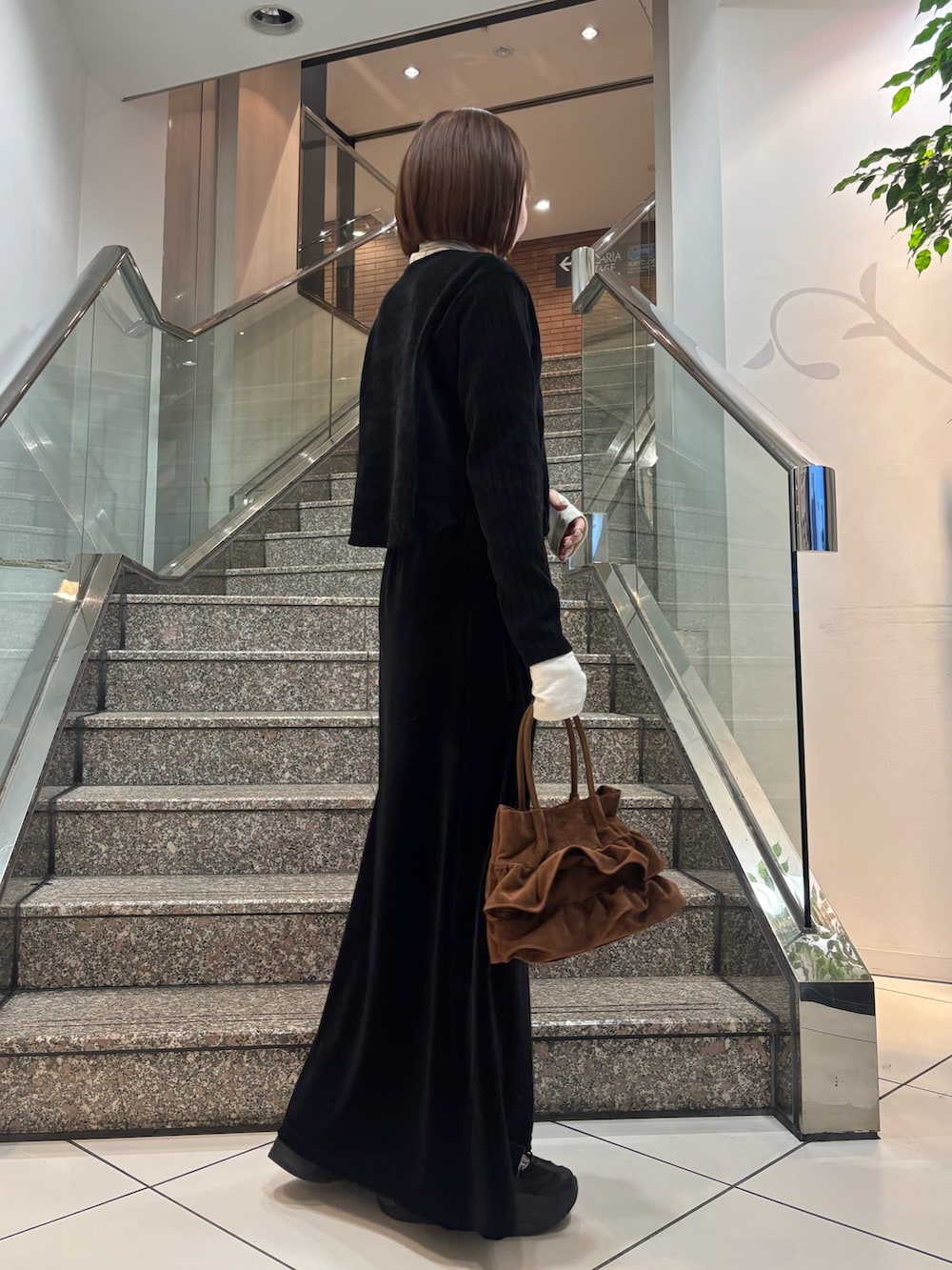 ホワイト系のTシャツ/カットソー、ブラック系のカーディガン/ボレロ、ブラック系のスカートを着用したレディースの冬コーディネートの3枚目の写真