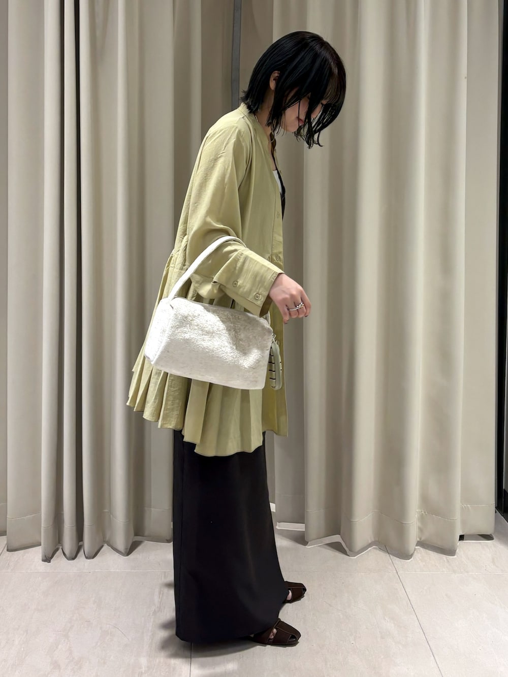 ブラウン系のTシャツ/カットソー、ブラウン系のスカート、ホワイト系のハンドバッグを着用したレディースの秋コーディネートの3枚目の写真
