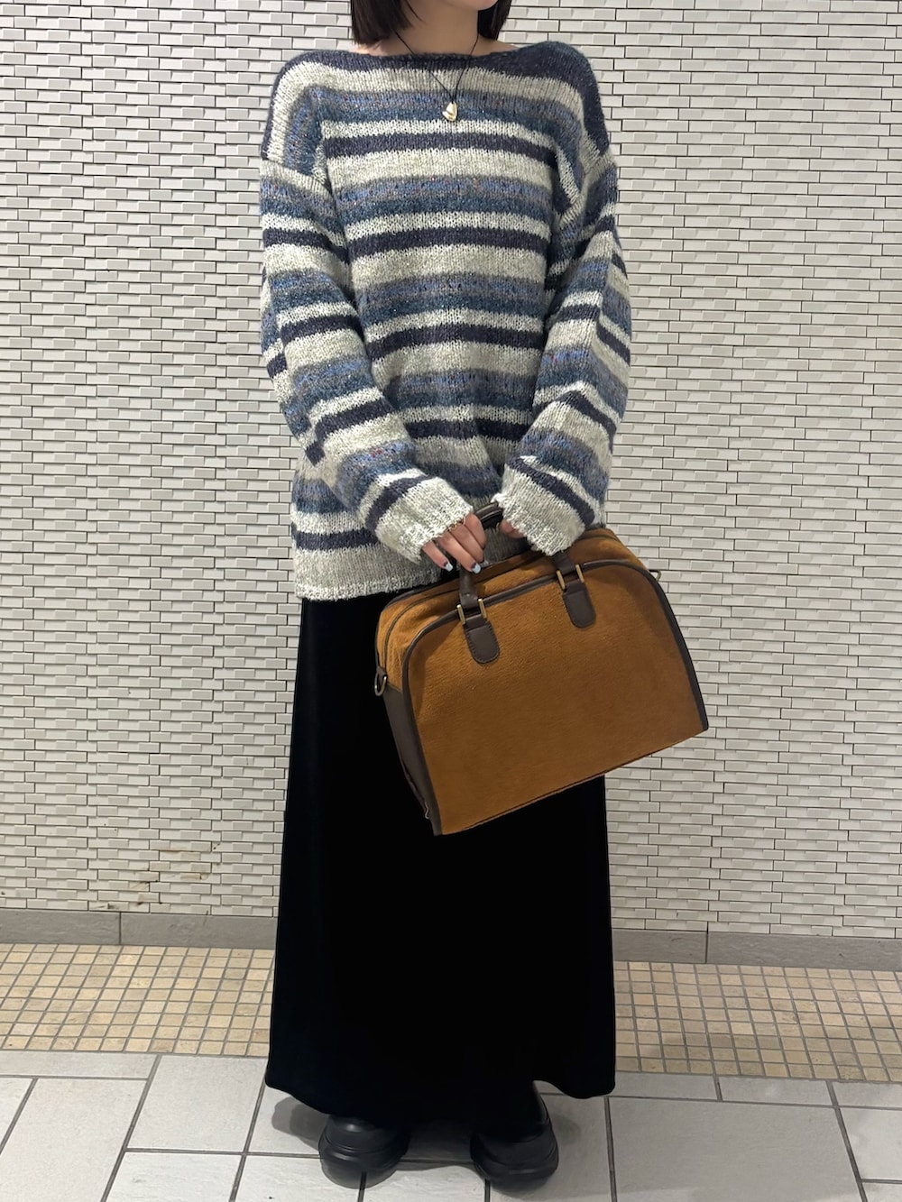 ブルー系のニット/セーター、ブラック系のスカート、イエロー系のボストンバッグを着用したレディースの秋コーディネートの4枚目の写真