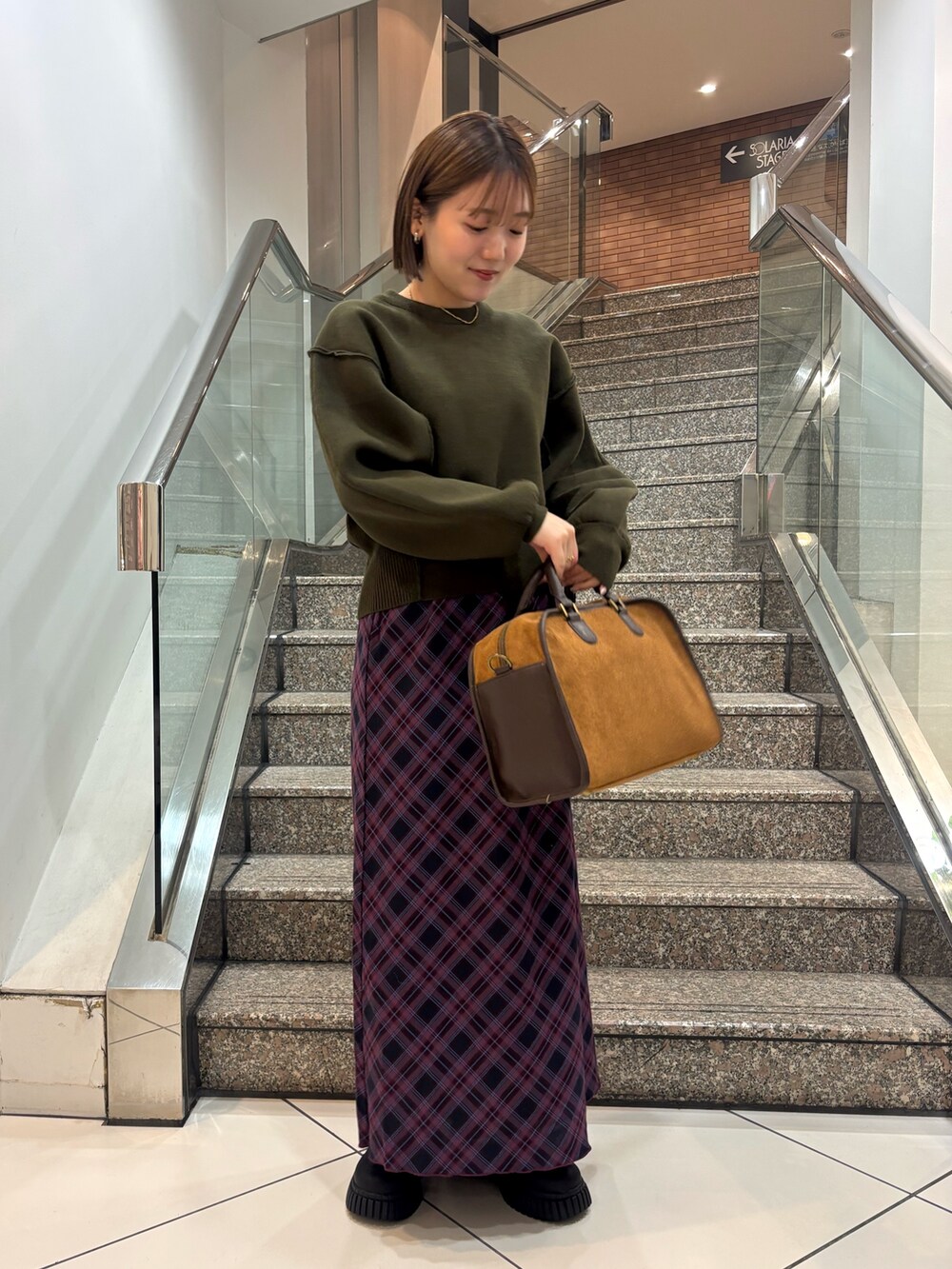 ブラック系のスニーカー、レッド系のスカート、イエロー系のボストンバッグを着用したレディースの冬コーディネートの4枚目の写真