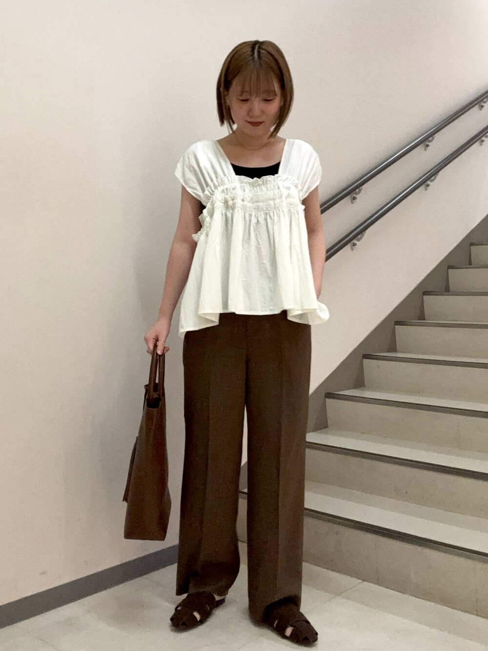 ブラウン系のその他パンツ、ブラウン系のサンダル、ホワイト系のシャツ/ブラウスを着用したレディースの夏コーディネートの5枚目の写真