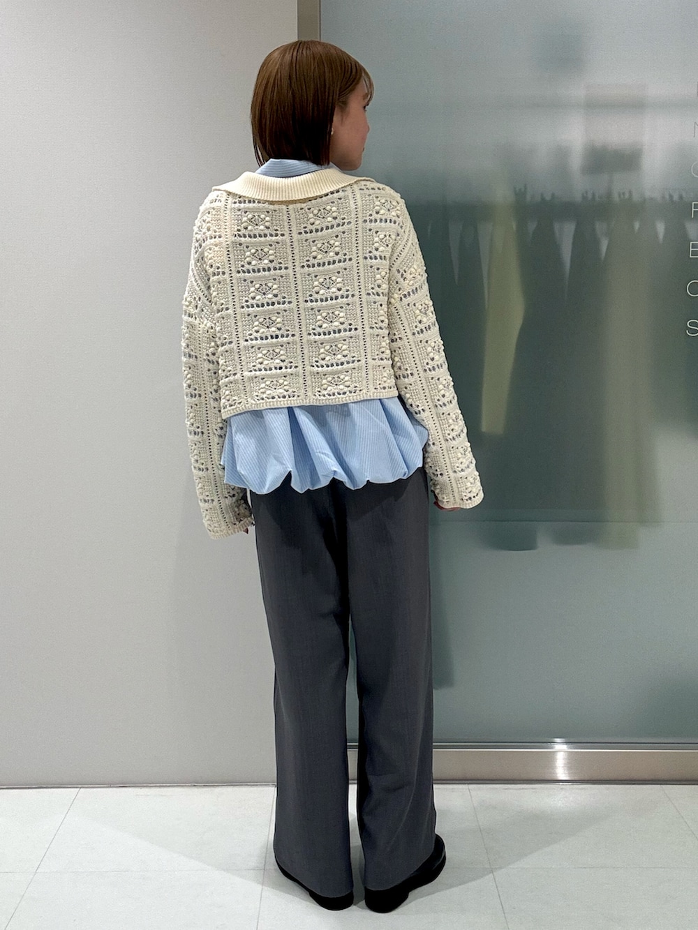 ホワイト系のカーディガン/ボレロ、ブルー系のシャツ/ブラウス、グレー系のスラックスを着用したレディースの春コーディネートの4枚目の写真