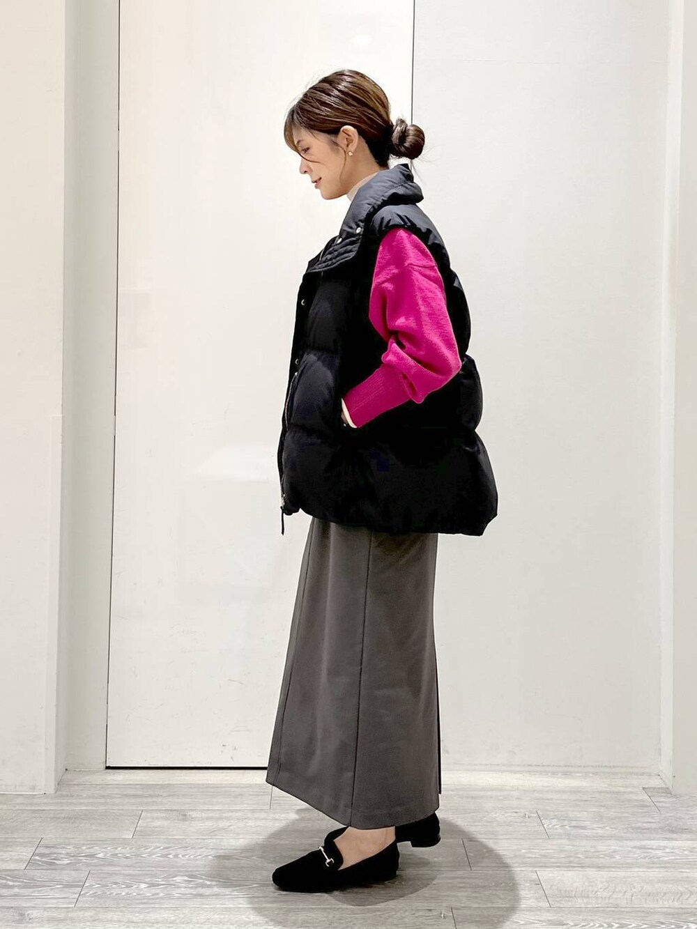 ピンク系のニット/セーター、ホワイト系のTシャツ/カットソー、グリーン系のスカートを着用したレディースの秋コーディネートの2枚目の写真