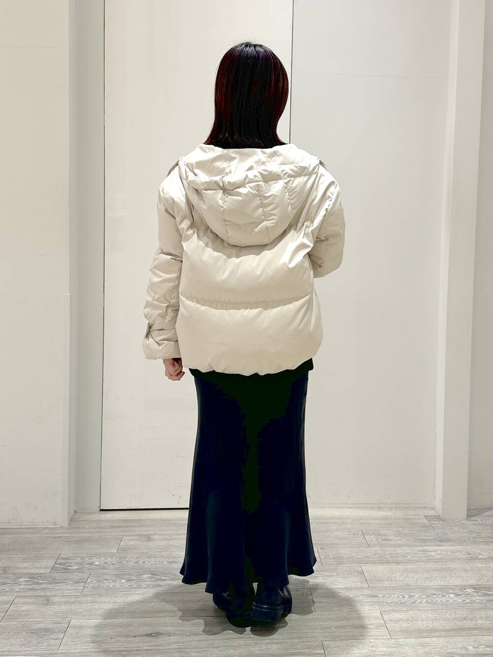 ホワイト系のダウンジャケット/コート、ブラック系のブーツ、ブラック系のニット/セーターを着用したレディースの冬コーディネートの3枚目の写真