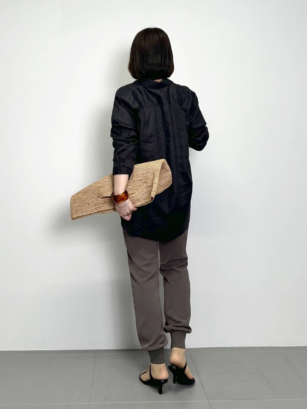 ホワイト系のTシャツ/カットソー、ブラウン系のトートバッグ、ブラウン系のその他パンツを着用したレディースの春コーディネートの3枚目の写真