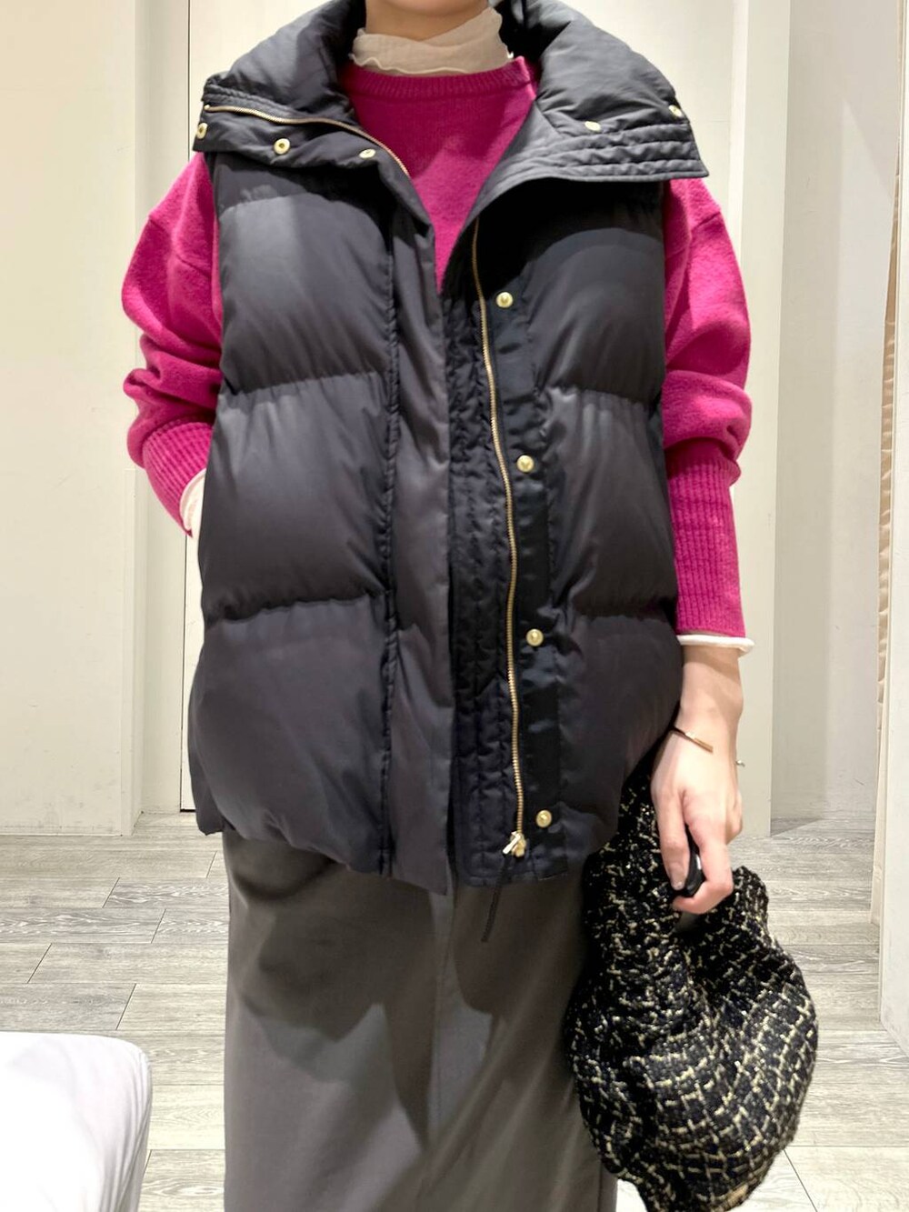 ピンク系のニット/セーター、ホワイト系のTシャツ/カットソー、グリーン系のスカートを着用したレディースの秋コーディネートの4枚目の写真