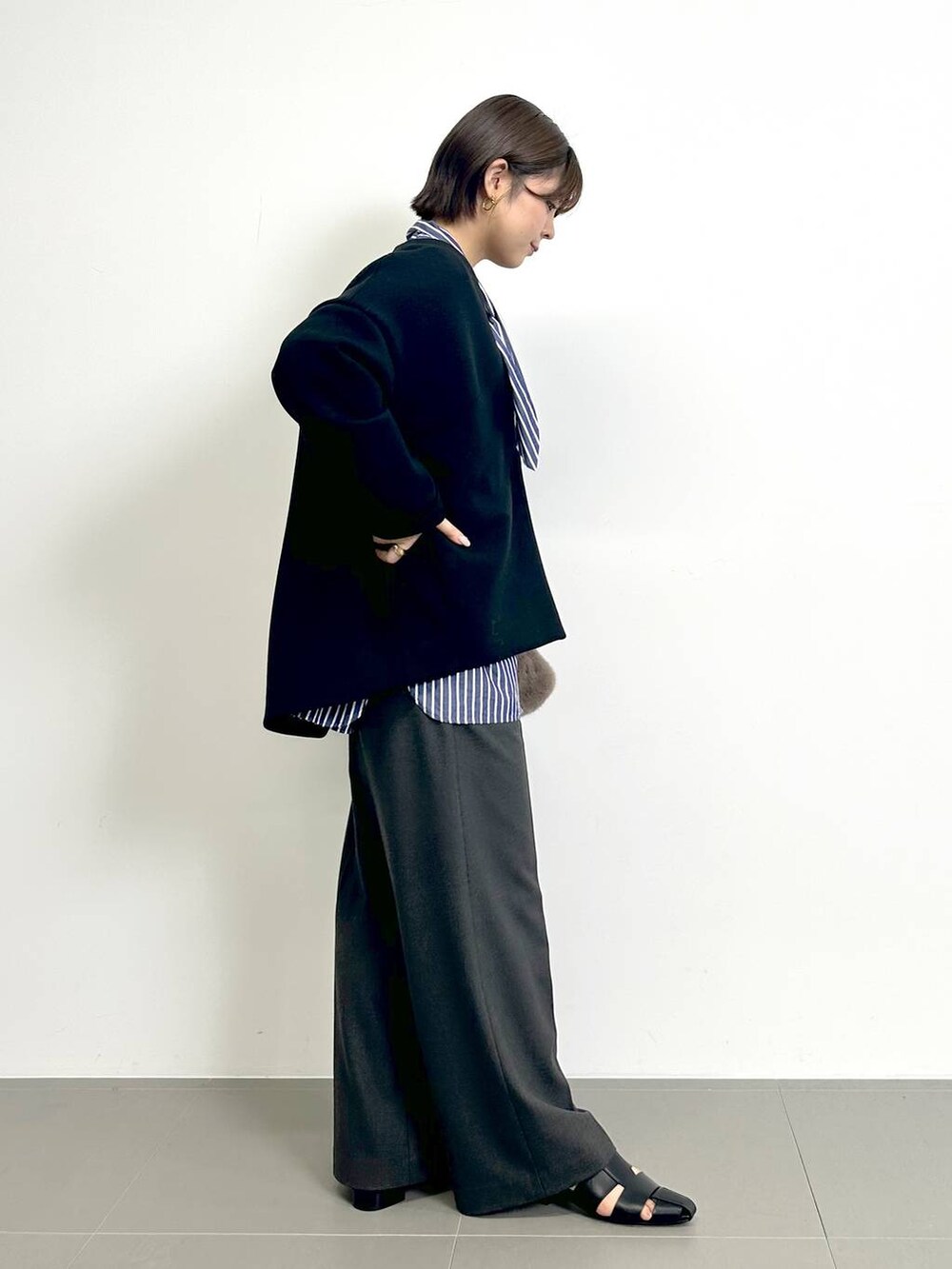 ブルー系のシャツ/ブラウス、ブラック系のパンプス、ブラウン系のトートバッグを着用したレディースの秋コーディネートの2枚目の写真