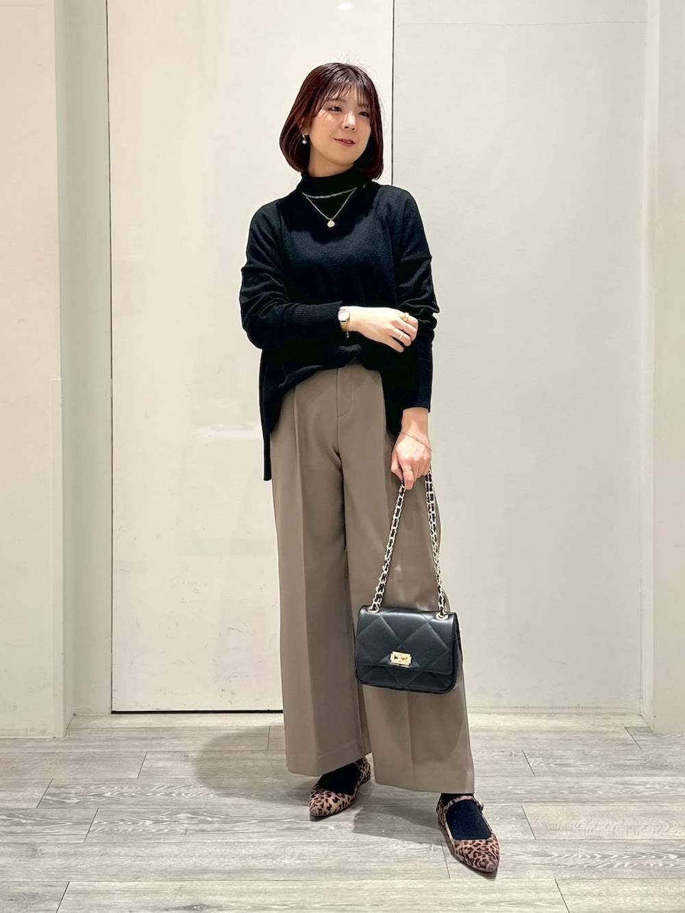 グレー系のテーラードジャケット、ブラック系のショルダーバッグ、ブラック系のニット/セーターを着用したレディースの冬コーディネートの2枚目の写真