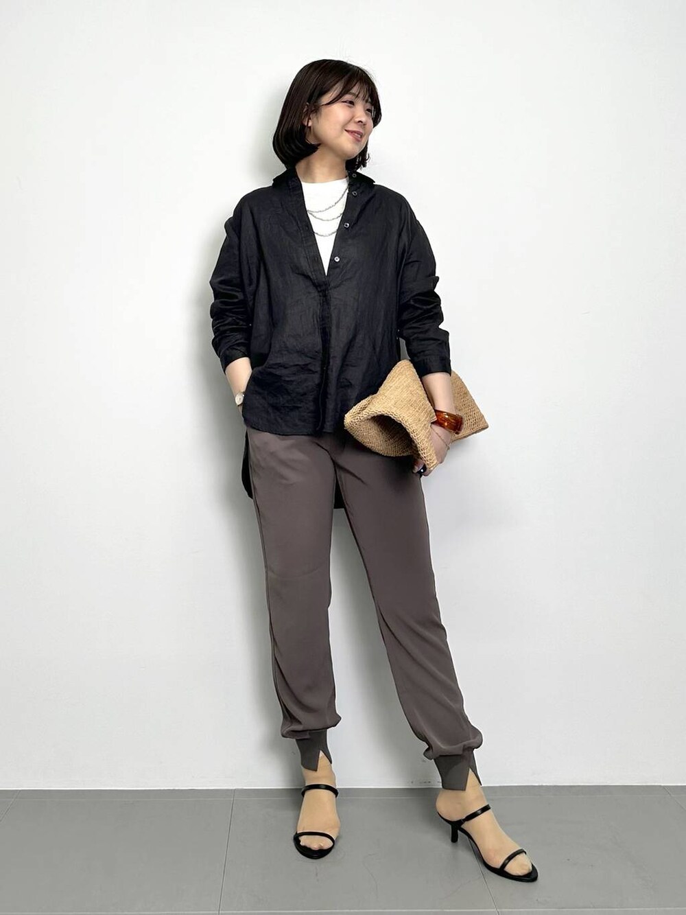 ホワイト系のTシャツ/カットソー、ブラウン系のトートバッグ、ブラウン系のその他パンツを着用したレディースの春コーディネートの2枚目の写真