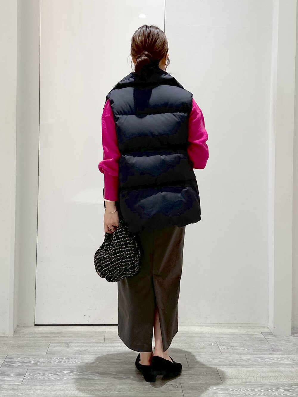 ピンク系のニット/セーター、ホワイト系のTシャツ/カットソー、グリーン系のスカートを着用したレディースの秋コーディネートの3枚目の写真