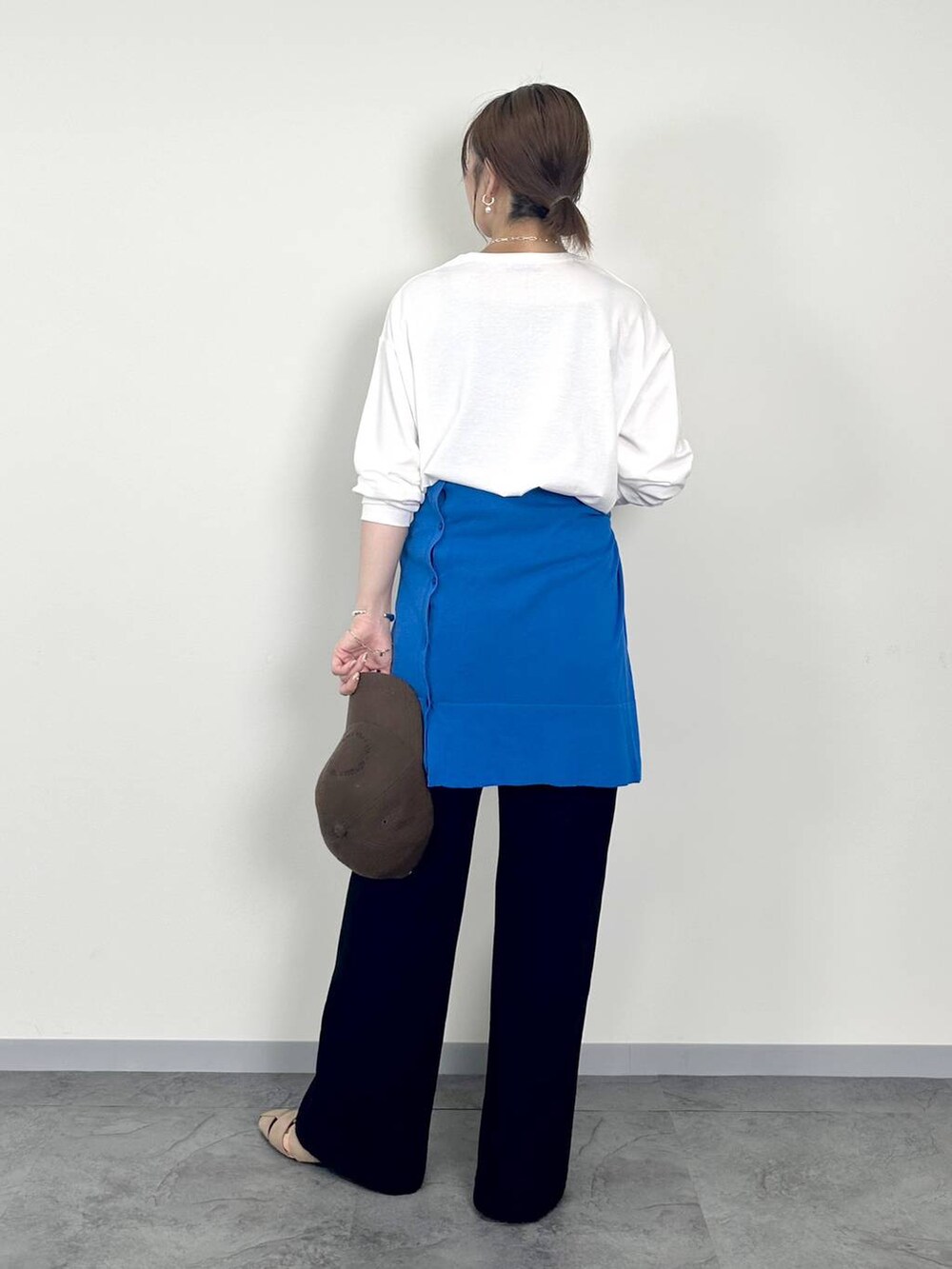 ブラック系のデニムパンツ、ブラウン系のパンプス、ブルー系のカーディガン/ボレロを着用したレディースの秋コーディネートの2枚目の写真