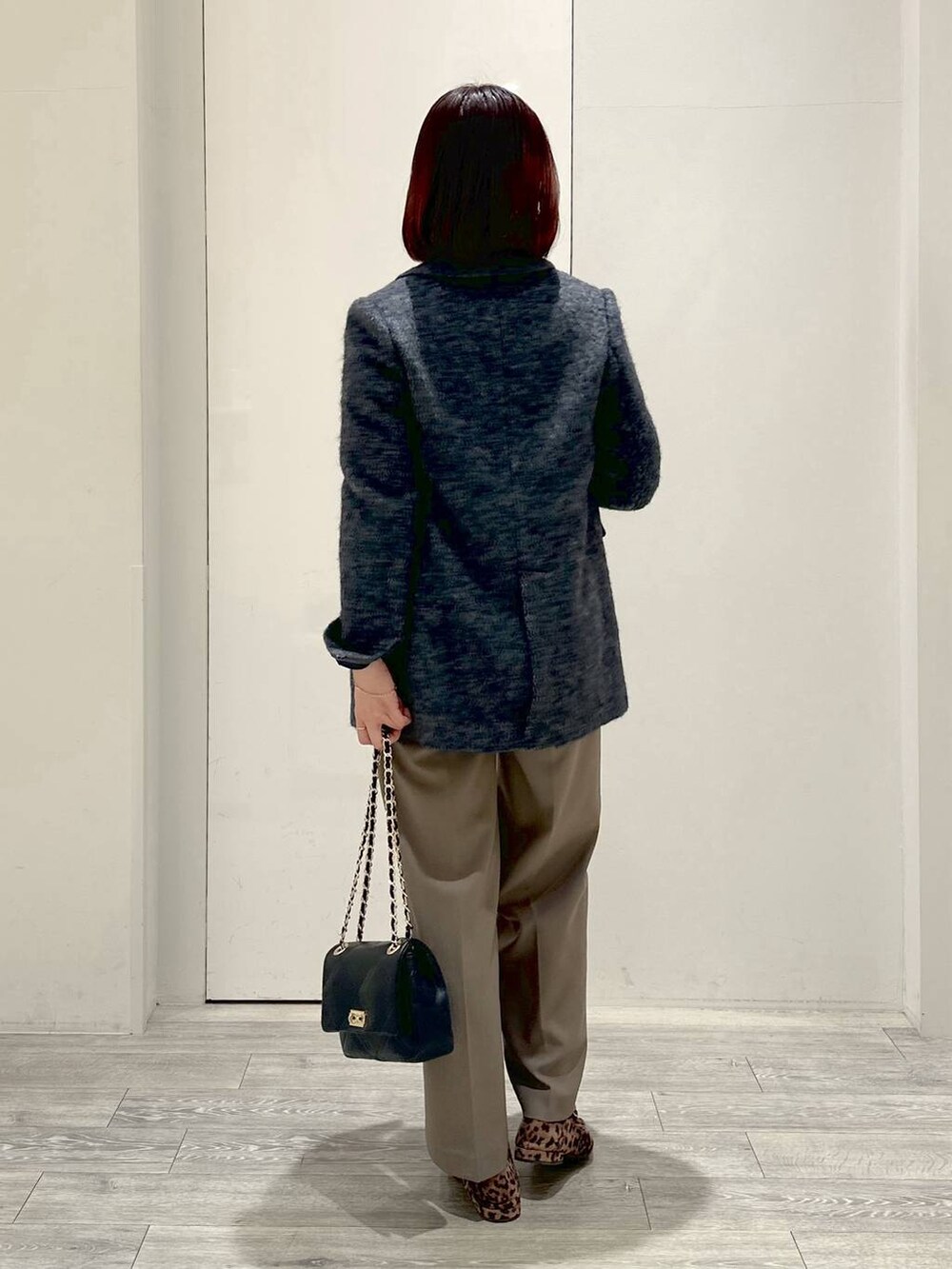 グレー系のテーラードジャケット、ブラック系のショルダーバッグ、ブラック系のニット/セーターを着用したレディースの冬コーディネートの3枚目の写真