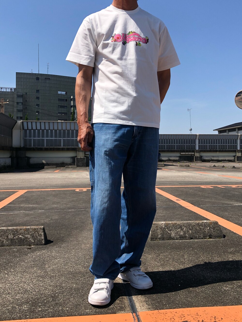 ホワイト系のTシャツ/カットソー、ブルー系のチノパンツ、グレー系のスニーカーを着用したメンズの夏コーディネートの3枚目の写真