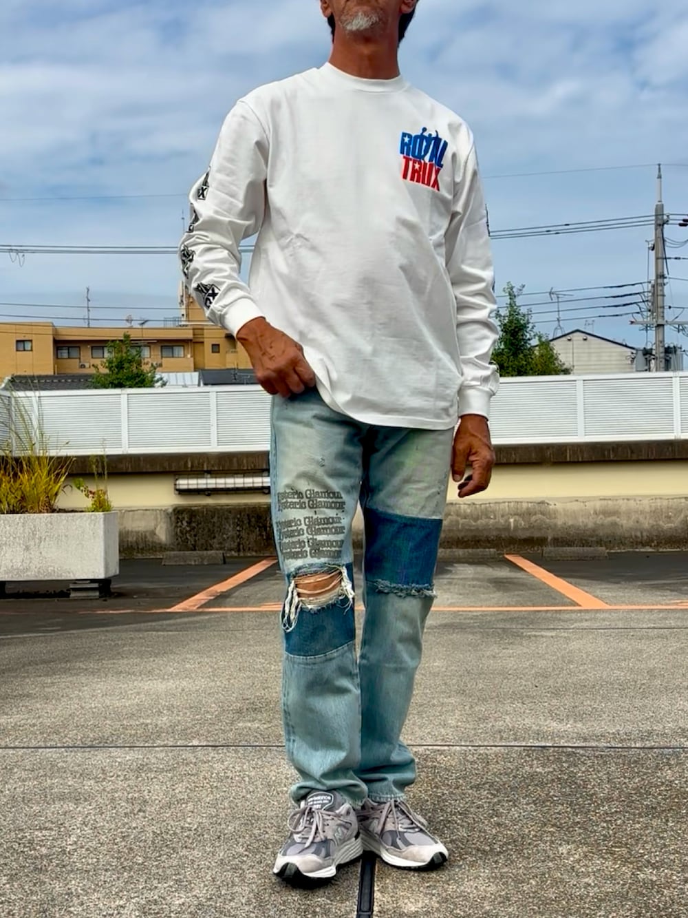 ホワイト系のTシャツ/カットソー、ブルー系のデニムパンツ、グレー系のスニーカーを着用したメンズの秋コーディネートの3枚目の写真