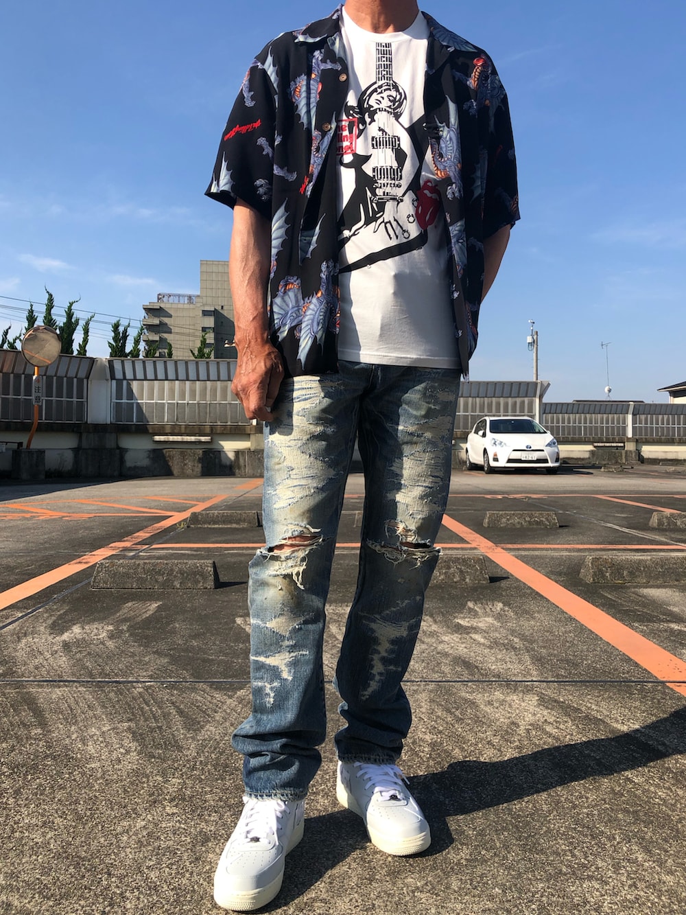 ホワイト系のTシャツ/カットソー、ブラック系のシャツ/ブラウス、ブルー系のデニムパンツを着用したメンズの夏コーディネートの2枚目の写真