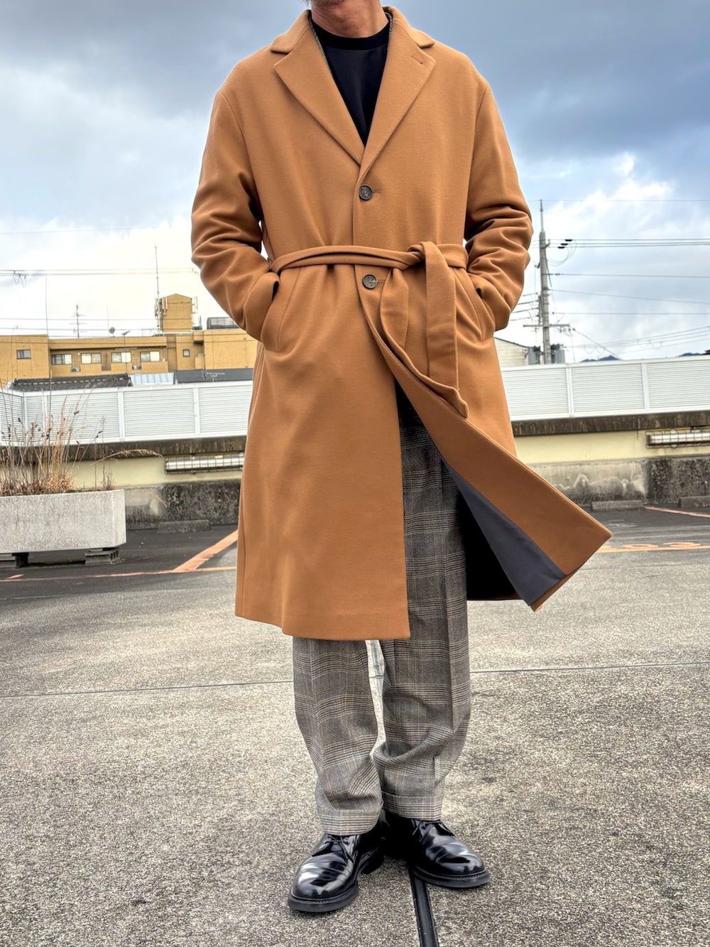 ブラウン系のスーツジャケット、ブラウン系のスーツパンツ、ブラック系のドレスシューズを着用したメンズの冬コーディネートの3枚目の写真