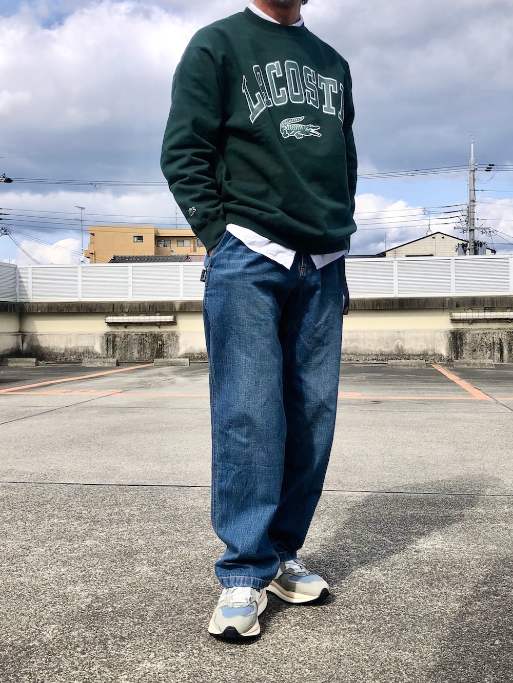 グリーン系のスウェット、ブルー系のデニムパンツ、グレー系のスニーカーを着用したメンズの春コーディネートの2枚目の写真