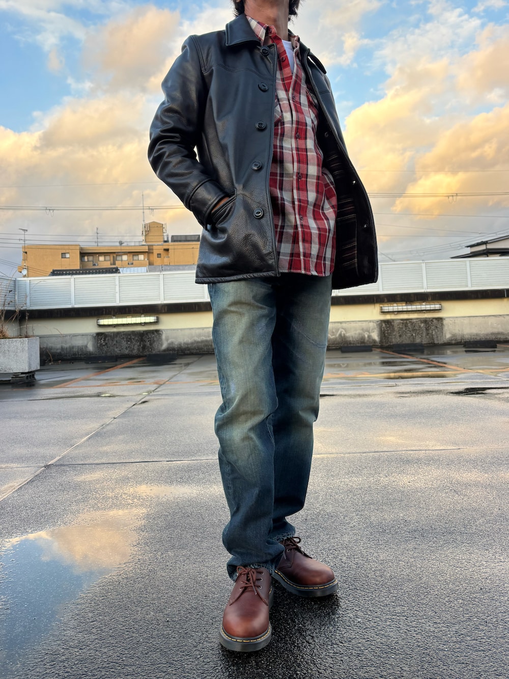 ブラック系のライダースジャケット、レッド系のシャツ/ブラウス、ブルー系のデニムパンツを着用したメンズの冬コーディネートの2枚目の写真
