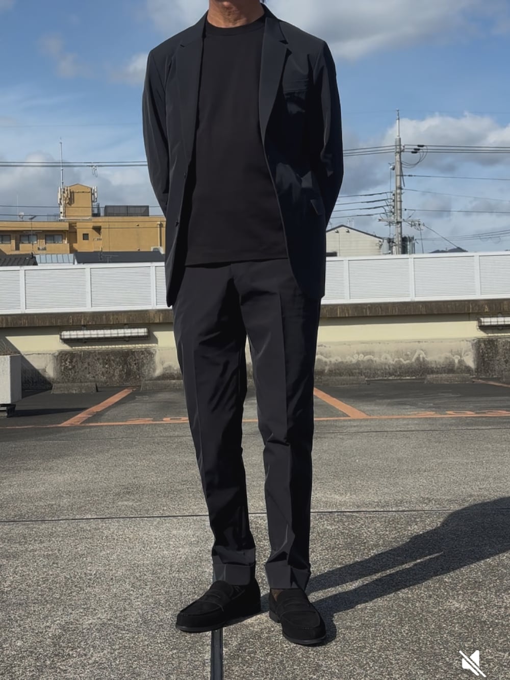ブラック系のTシャツ/カットソー、ブラック系のテーラードジャケット、ブラック系のスーツパンツを着用したメンズの春コーディネートの2枚目の写真