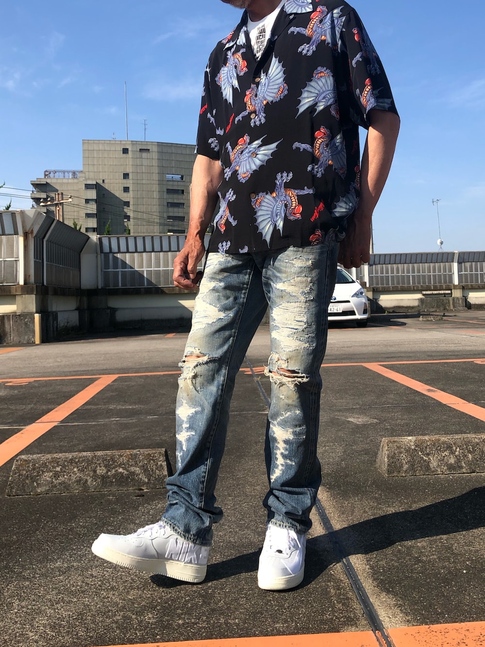 ホワイト系のTシャツ/カットソー、ブラック系のシャツ/ブラウス、ブルー系のデニムパンツを着用したメンズの夏コーディネートの4枚目の写真