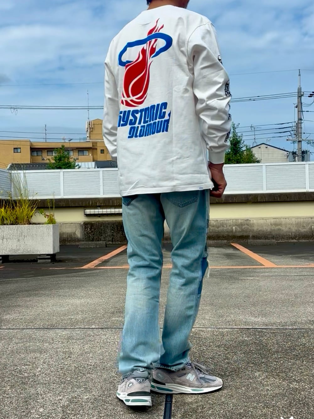 ホワイト系のTシャツ/カットソー、ブルー系のデニムパンツ、グレー系のスニーカーを着用したメンズの秋コーディネートの2枚目の写真