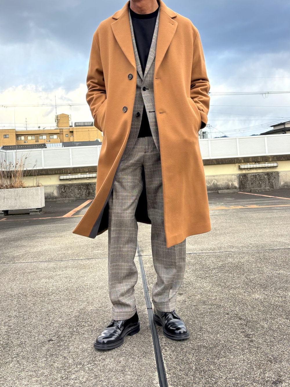 ブラウン系のスーツジャケット、ブラウン系のスーツパンツ、ブラック系のドレスシューズを着用したメンズの冬コーディネートの2枚目の写真