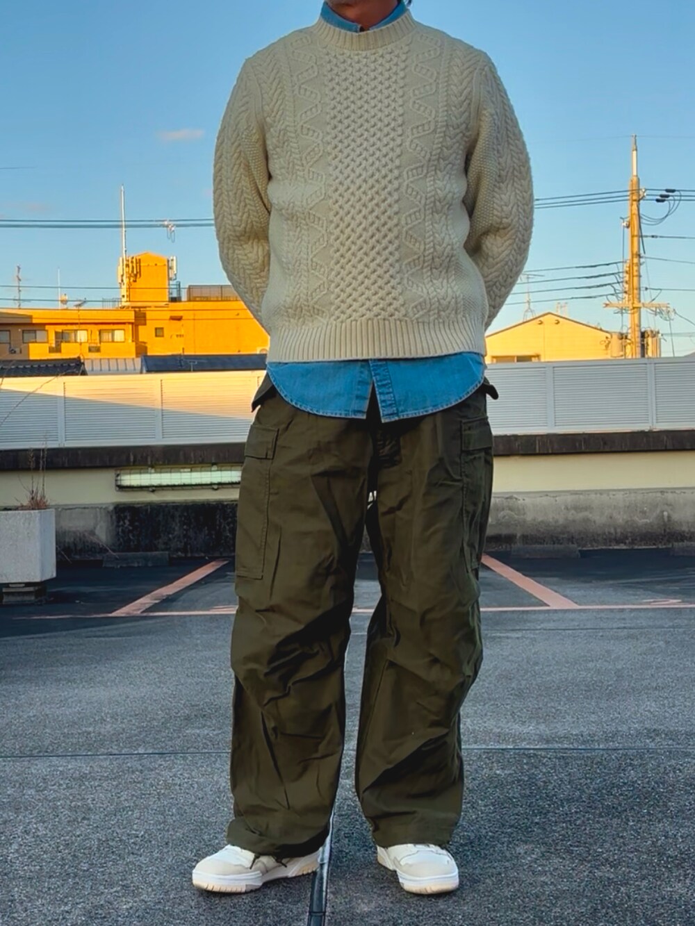 グリーン系のカーゴパンツ、ブルー系のシャツ/ブラウス、ホワイト系のニット/セーターを着用したメンズの冬コーディネートの3枚目の写真