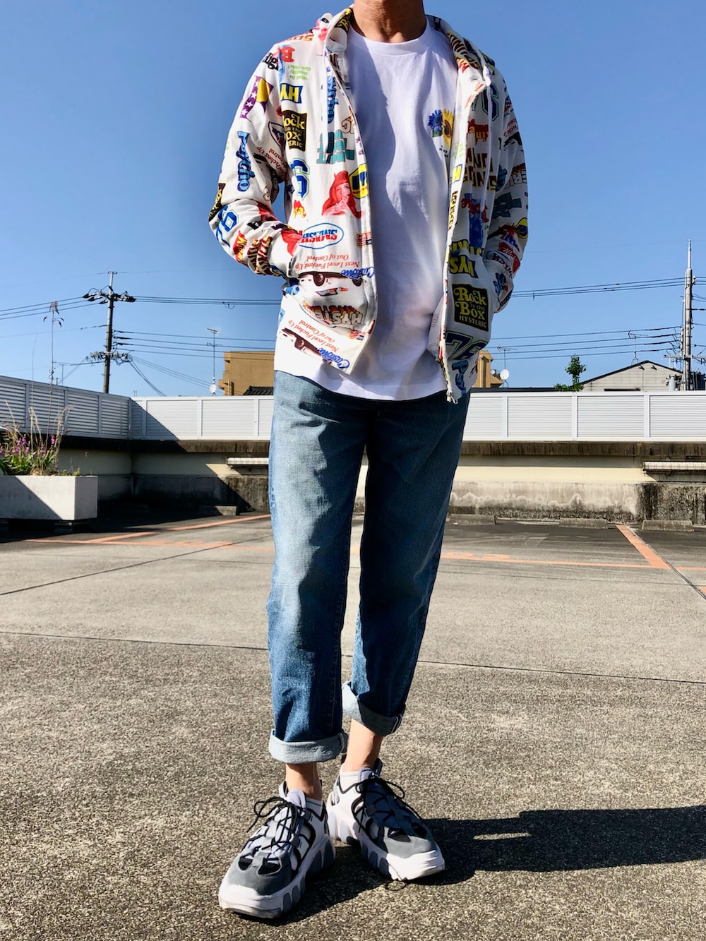 ホワイト系のパーカー、ホワイト系のTシャツ/カットソー、ブルー系のデニムパンツを着用したメンズの春コーディネートの2枚目の写真