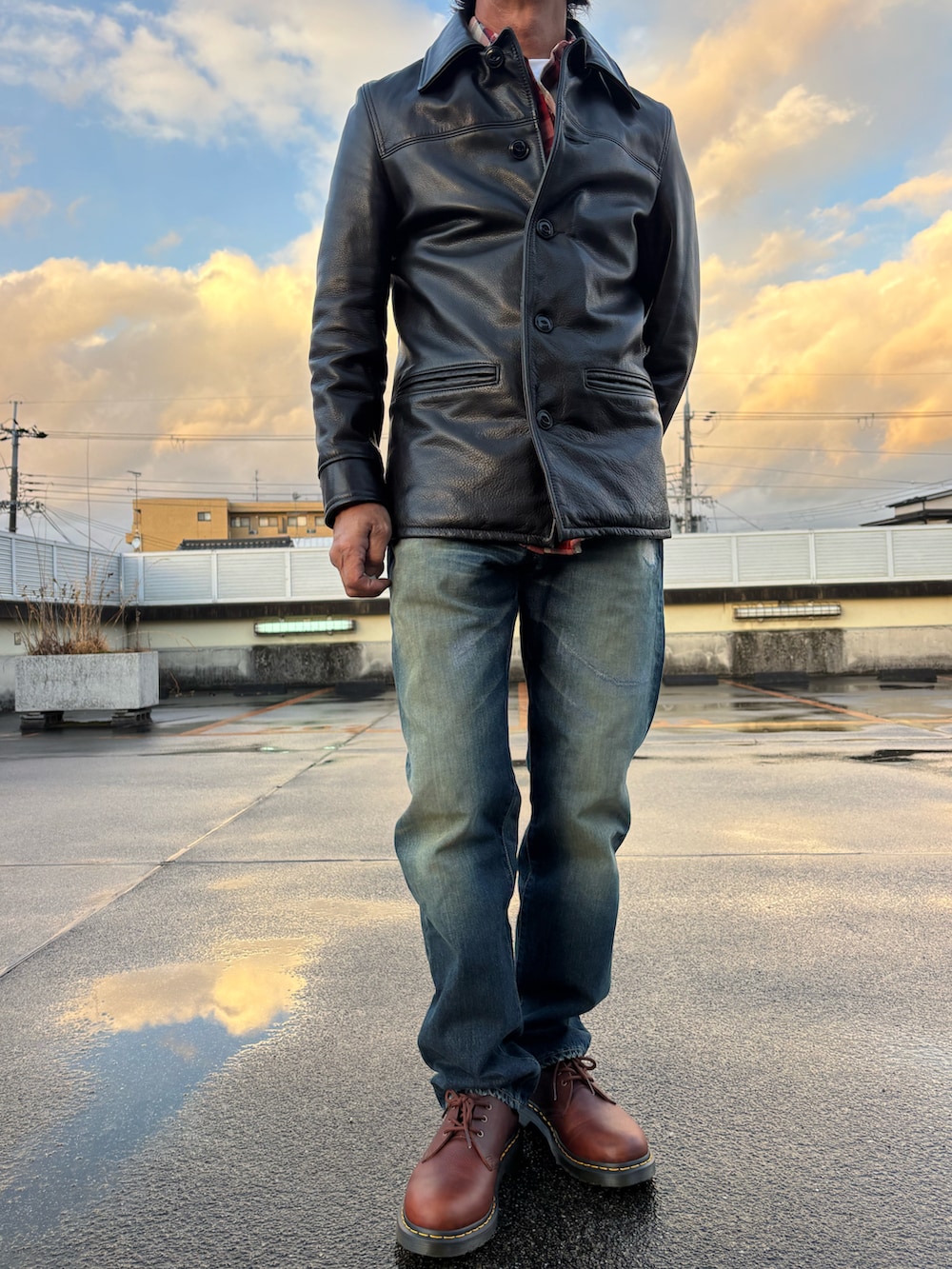 ブラック系のライダースジャケット、レッド系のシャツ/ブラウス、ブルー系のデニムパンツを着用したメンズの冬コーディネートの4枚目の写真