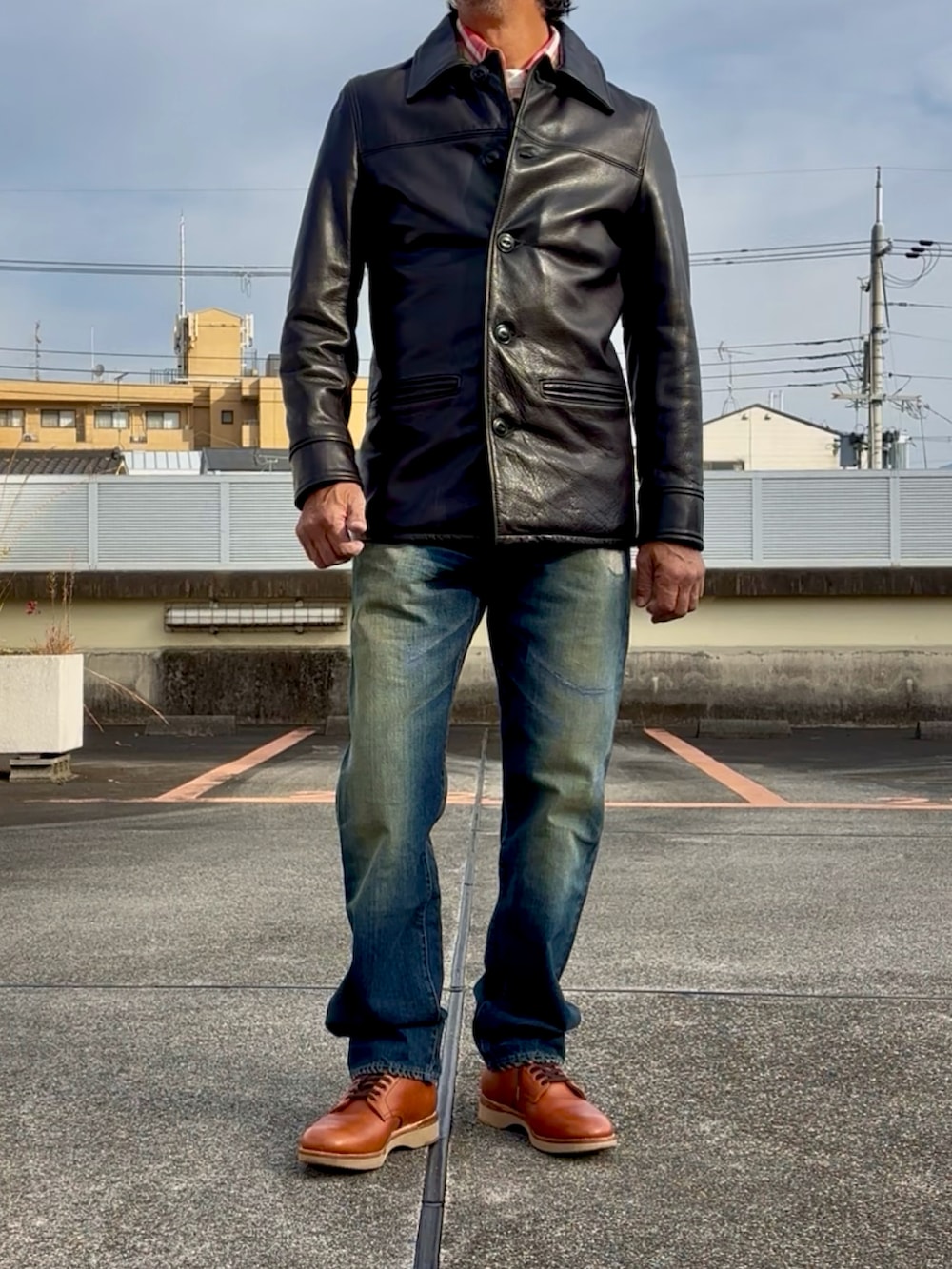 ブルー系のシャツ/ブラウス、ブルー系のデニムパンツ、ブラック系のライダースジャケットを着用したメンズの秋コーディネートの4枚目の写真