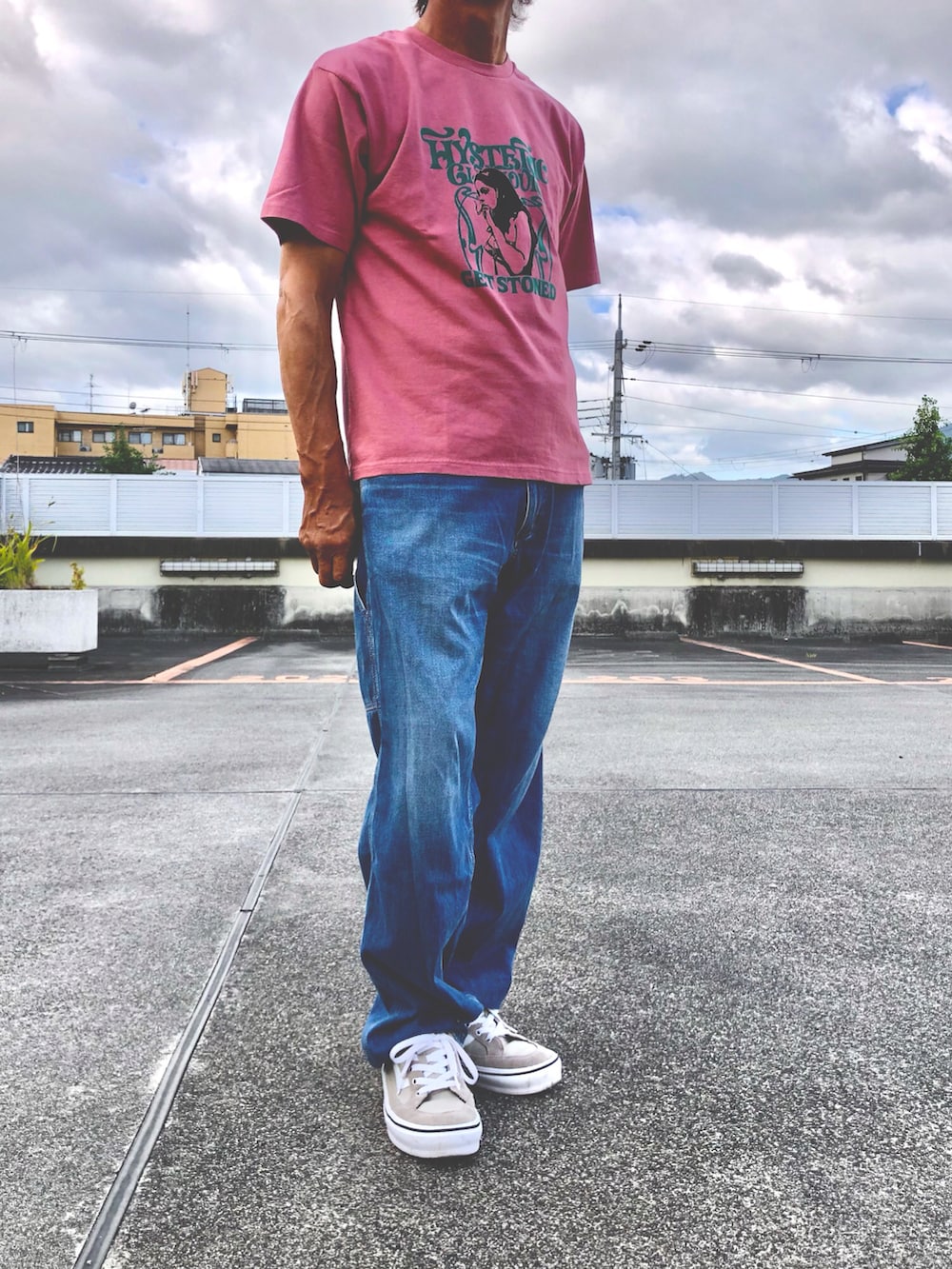ピンク系のTシャツ/カットソー、ブルー系のチノパンツ、ベージュ系のスニーカーを着用したメンズの夏コーディネートの2枚目の写真