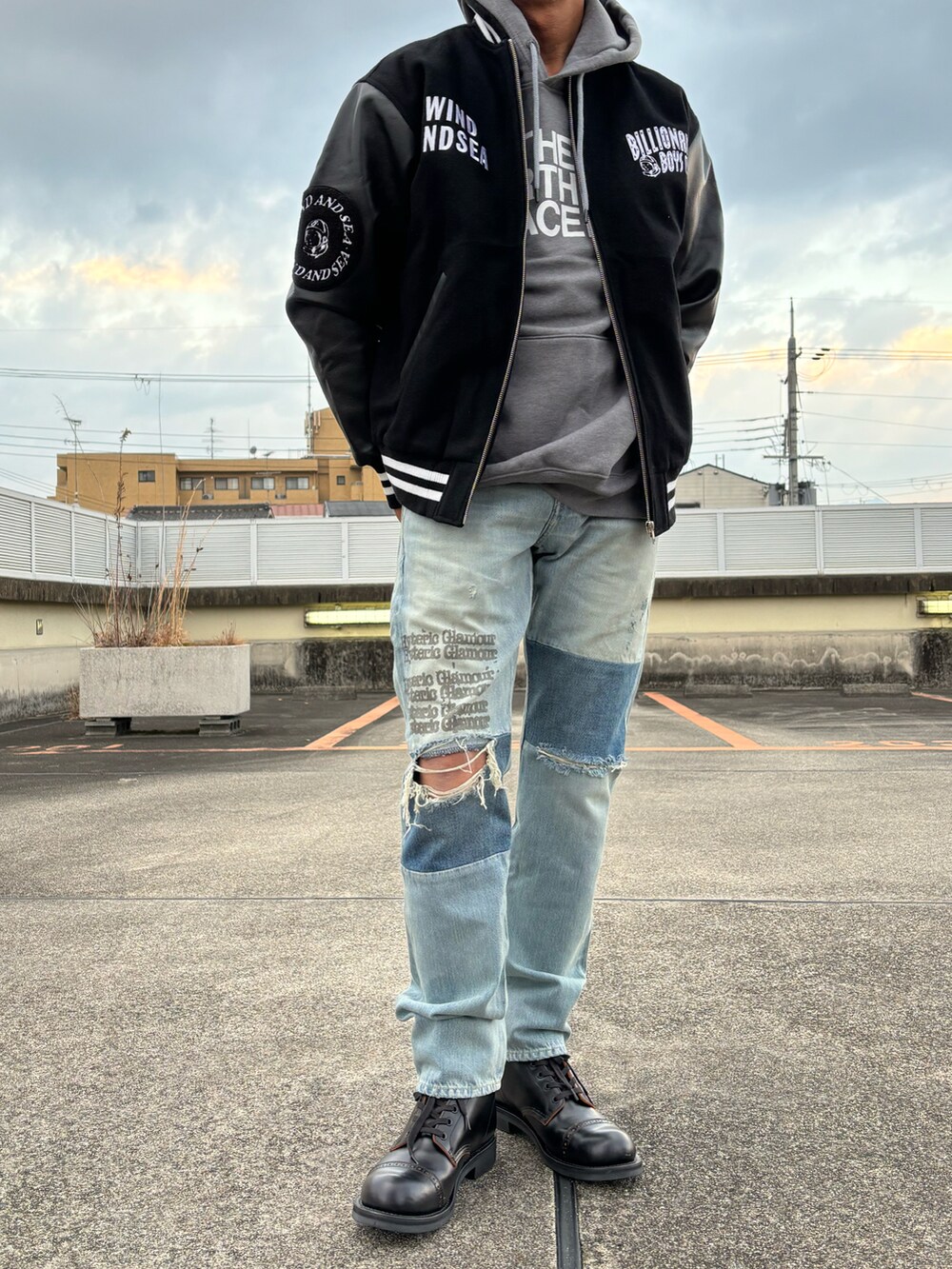 ブラック系のブルゾン、ブルー系のデニムパンツ、グレー系のパーカーを着用したメンズの冬コーディネートの2枚目の写真