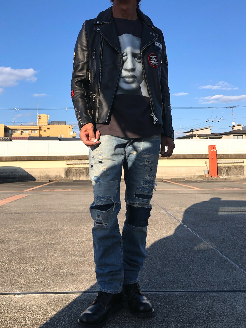 ブラック系のライダースジャケット、ブラック系のTシャツ/カットソー、ブルー系のデニムパンツを着用したメンズの冬コーディネートの2枚目の写真
